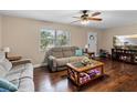 Cozy living room with hardwood floors, comfortable seating, ceiling fan, and a fireplace at 1135 5Th St, Orange City, FL 32763