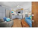 Cozy living room featuring blue sofa, gray chair, and an eat-in kitchen with stainless steel appliances at 1167 Ocean Shore Blvd # 110, Ormond Beach, FL 32176