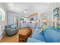 Bright living room featuring a blue sofa, gray chair, and eat-in kitchen with stainless steel appliances at 1167 Ocean Shore Blvd # 110, Ormond Beach, FL 32176