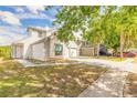 View of the home showing a well-manicured lawn and a long driveway leading to the garage at 1229 Saddleback Ridge Rd, Apopka, FL 32703
