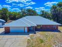 A bird's eye view of this home, with its sprawling roof, garage, and spacious front yard at 1371 Merrifield Ct, Deltona, FL 32725