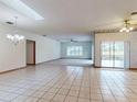 Spacious living room featuring tile floors, a ceiling fan, and a sliding glass door at 1371 Merrifield Ct, Deltona, FL 32725
