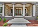 Elegant entrance with double doors, white pillars, and stone accents create a welcoming facade at 1420 Shady Meadow Ln, Deland, FL 32724