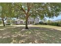 Suburban home with mature trees and a lush front lawn, creating a park-like setting at 1420 Shady Meadow Ln, Deland, FL 32724