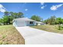 Light blue single-story home with a long driveway leading to an attached one car garage at 1598 Montgomery Ave, Daytona Beach, FL 32117