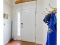 Bright entryway with coat rack, white door, and warm-toned tile flooring at 161 Blue Heron Dr # C, Daytona Beach, FL 32119