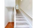 Carpeted staircase with white railing, adjacent to tiled flooring, in a bright home at 161 Blue Heron Dr # C, Daytona Beach, FL 32119