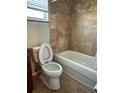 Bathroom features a tiled shower and tub, toilet, and window at 1649 Courtland Blvd, Deltona, FL 32738