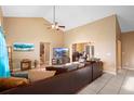 Comfortable living room with vaulted ceilings, tile flooring, and a large sofa, perfect for relaxing and entertaining guests at 1731 Urbana Ave, Deltona, FL 32725
