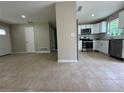 Open-concept layout showcasing the kitchen with stainless steel appliances, white cabinets, and seamless flow to the living area at 1808 Green Pl, Ormond Beach, FL 32174