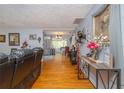 Open-concept living room featuring hardwood floors and decorative ceiling and view to kitchen at 220 Buena Vista St, Debary, FL 32713