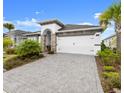 Inviting single-story home showcasing a paved driveway, tidy landscaping, and an attached two-car garage at 225 Mosaic Blvd, Daytona Beach, FL 32124