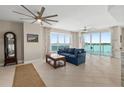 Bright living room featuring a comfortable blue sofa, ceiling fans, and stunning waterfront views at 241 Riverside Dr # 902, Holly Hill, FL 32117