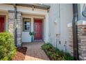 Inviting front entrance with a red door, stone accents, and lush landscaping creates curb appeal at 258 Rustic Loop, Sanford, FL 32771