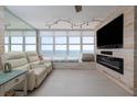 Cozy living room featuring an electric fireplace, a large window showcasing ocean views, and comfortable seating at 2800 N Atlantic Ave # 1715, Daytona Beach, FL 32118