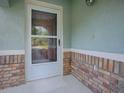 Welcoming front porch with decorative brickwork and a storm door at 307 Stonington Way, Deland, FL 32724