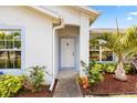 Inviting front entrance with a white door, blue trim, and lush landscaping around the entryway at 3214 Juniper Dr, Edgewater, FL 32141