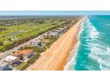 Expansive aerial view featuring beachfront properties, golf courses, and the beautiful coastline at 33 Ocean Shore Blvd, Ormond Beach, FL 32176