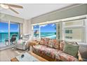 Inviting living area featuring tropical-patterned sofa and ample natural light from the expansive ocean-view windows at 3311 S Atlantic Ave # 1704, Daytona Beach Shores, FL 32118