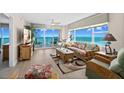 Bright living room with ocean views through sliding glass doors and windows, plus tropical-themed furniture at 3311 S Atlantic Ave # 1704, Daytona Beach Shores, FL 32118