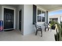 Inviting front porch with two chairs, a large window, and stylish black front door at 34568 Shellback St, Leesburg, FL 34788