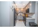 Remodeled kitchen featuring grey cabinets, granite counters, and stainless steel appliances at 3800 Saxon Dr # 150, New Smyrna Beach, FL 32169