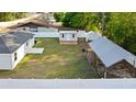 Large, fenced backyard featuring a shed, a lean-to for covered storage, and ample green space for outdoor activities at 430 Spring Dr, Ocala, FL 34472