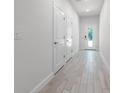Well-lit hallway featuring wood-look tile flooring and access to other rooms at 561 Coronado Cove Road, New Smyrna Beach, FL 32168