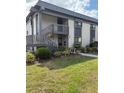 Exterior of a well-maintained two-story condo with charming landscaping, plants and a lawn at 600 N Boundary Ave # 114-C, Deland, FL 32720