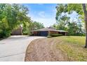 Sprawling single-story brick home with an attached garage, long driveway, and a detached garage on a large lot at 6185 Shoreline Dr, Port Orange, FL 32127