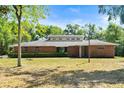 Charming single-story brick home featuring a well-kept lawn, unique clerestory windows, and a modern front door at 6185 Shoreline Dr, Port Orange, FL 32127