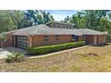 Charming brick home with a modern garage door, well-maintained landscaping, and a contemporary roof design at 6185 Shoreline Dr, Port Orange, FL 32127