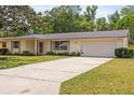 Charming single-story home with a well-maintained lawn, attached garage, and inviting curb appeal at 736 Lindenwood W Cir, Ormond Beach, FL 32174