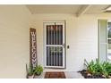 A cozy front porch featuring a decorative welcome sign, potted plants, and a 'hello' doormat at 736 Lindenwood W Cir, Ormond Beach, FL 32174