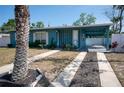 Charming blue house featuring a covered entryway, and drought resistant landscaping at 925 Halstead St, Deltona, FL 32725