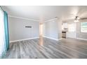 Bright living room with contemporary gray walls, modern wood-look floors, and open access to the kitchen at 925 Halstead St, Deltona, FL 32725