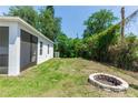 Spacious backyard with green grass, privacy fence, and a brick fire pit at 1005 Flagler Ave, Edgewater, FL 32132