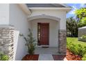 Stylish home entrance with brick columns, modern door, and manicured landscaping at 1005 Flagler Ave, Edgewater, FL 32132
