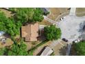 An aerial view of a well-maintained home with a brown roof in a mature, tree-lined neighborhood at 1057 Shady Hollow Dr, Deland, FL 32724