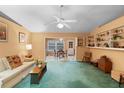 Spacious living room featuring built-in shelves, comfortable seating, and seamless access to the dining area at 1057 Shady Hollow Dr, Deland, FL 32724