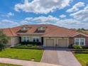 Beautiful single Gathering home featuring a red tile roof, manicured lawn, and a two-car garage at 1079 Quaker Ridge Ln, Davenport, FL 33896