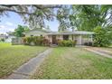 Charming single-story home featuring a lush front yard, covered parking, and mature landscaping at 1090 Wakefield Cir, Deltona, FL 32725