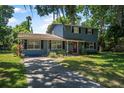 Inviting two-story house with a classic design, lush front lawn and mature trees shading the property at 1228 Oakwood Ave, Daytona Beach, FL 32114