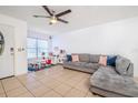 Inviting living room featuring a cozy gray sectional, tile flooring, and ample natural light at 1343 Rocky Rd, Kissimmee, FL 34744