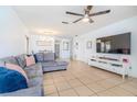 Open living space with gray sectional, entertainment center, and seamless flow to the dining area at 1343 Rocky Rd, Kissimmee, FL 34744
