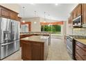 Spacious kitchen features stainless steel appliances, granite countertops, an island, and large windows overlooking the backyard at 1481 Areca Palm Dr, Port Orange, FL 32128