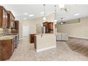 Modern kitchen with wood cabinets, granite countertops, stainless steel appliances, and an eat-in bar open to the living room at 1481 Areca Palm Dr, Port Orange, FL 32128