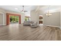 Open-concept living room with wood floors, a ceiling fan, and sliding glass doors to the backyard at 1481 Areca Palm Dr, Port Orange, FL 32128