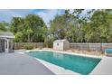 Backyard pool with adjacent storage shed and privacy fence surrounded by mature trees for shade and seclusion at 1590 Urbana Ave, Deltona, FL 32725
