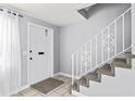 Bright entryway featuring tile flooring, a staircase with decorative railing, and a white front door at 1600 S Palmetto Ave # 105, South Daytona, FL 32119